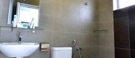 A modern bathroom with a toilet, sink, and shower.