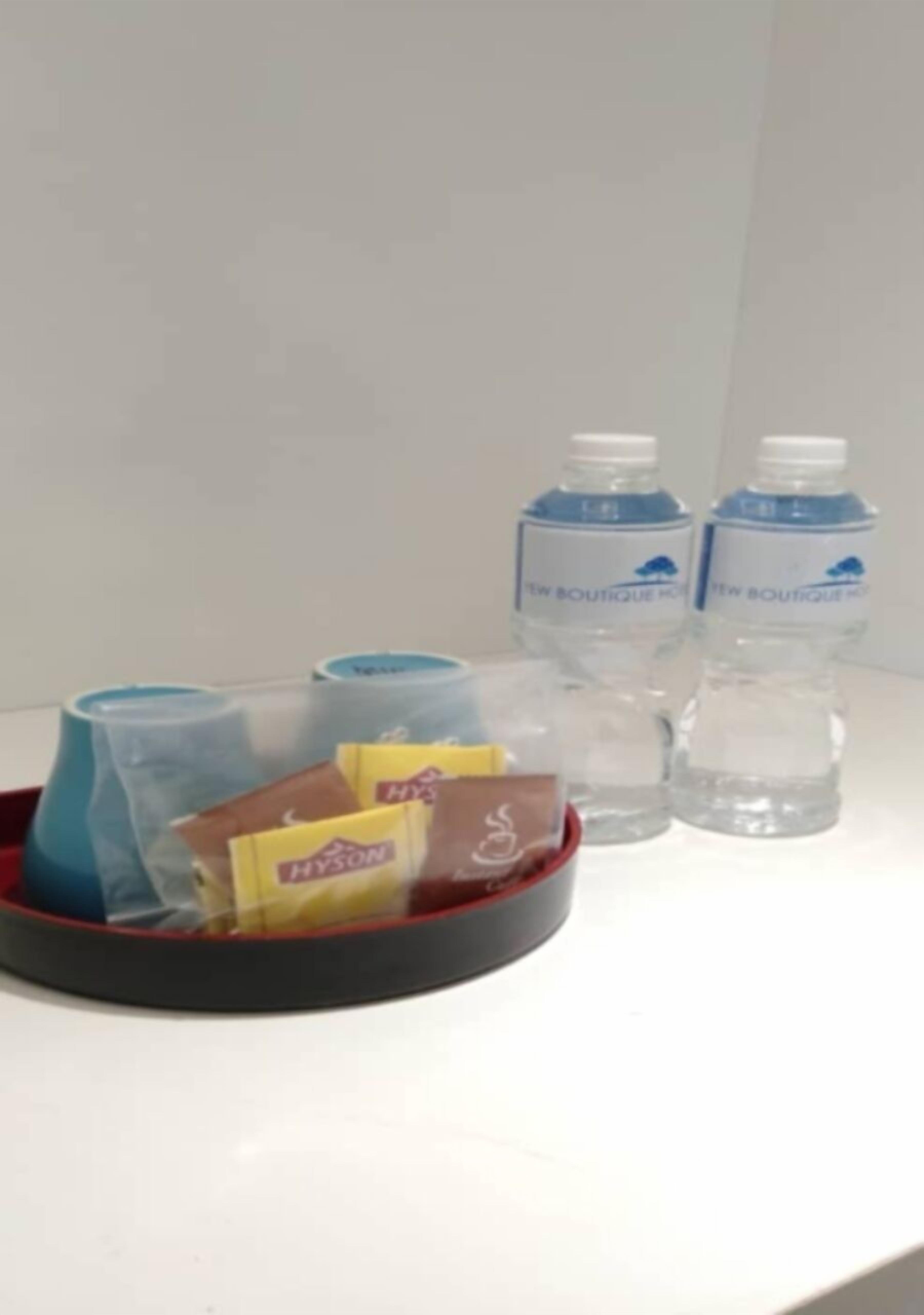 De minibar van een hotelkamer met een dienblad waarop een fles Hyscon, zakdoekjes en een kleine verpakking staan.