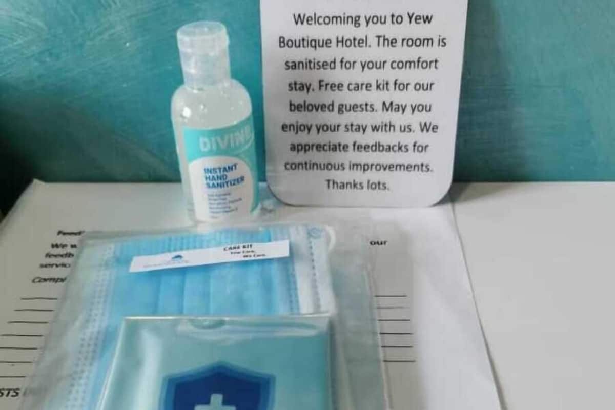 A welcome card, a bottle of hand sanitizer, and a package of sanitizing wipes with a blue cross symbol.