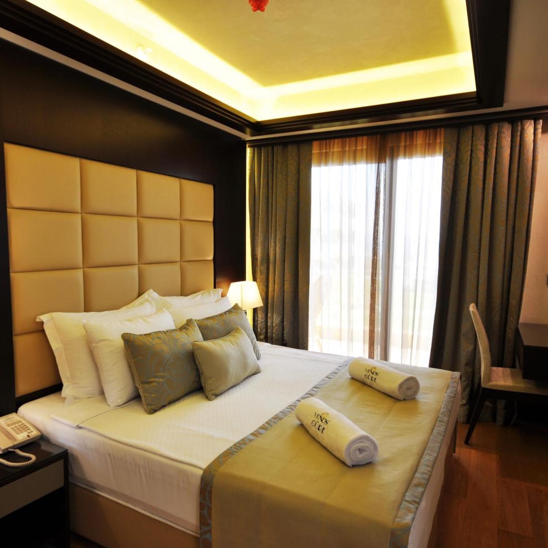 Een hotelkamer met een groot bed, een bedtelefoon en een stoel.