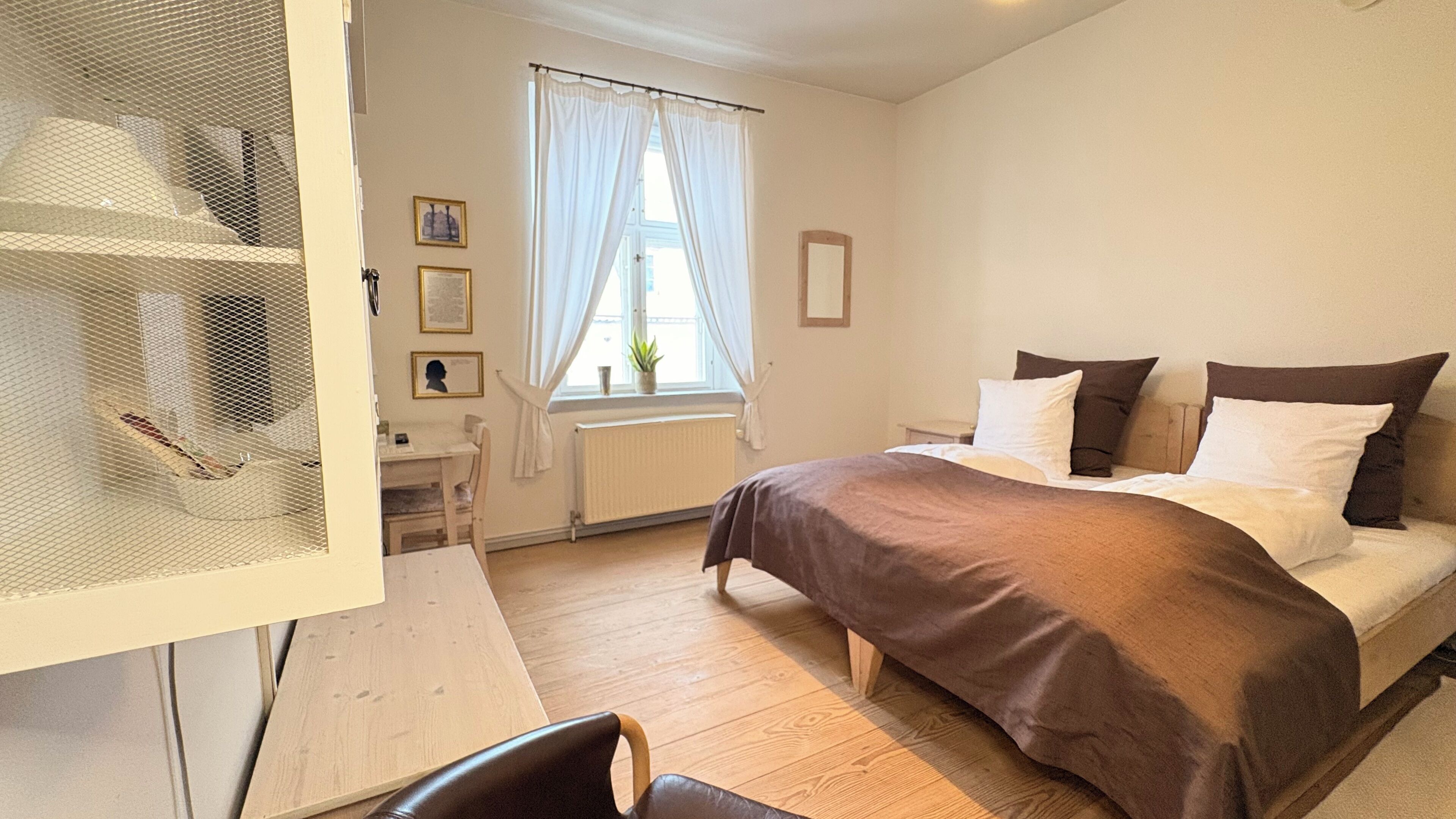 A bedroom with a bed, a desk, and a chair.