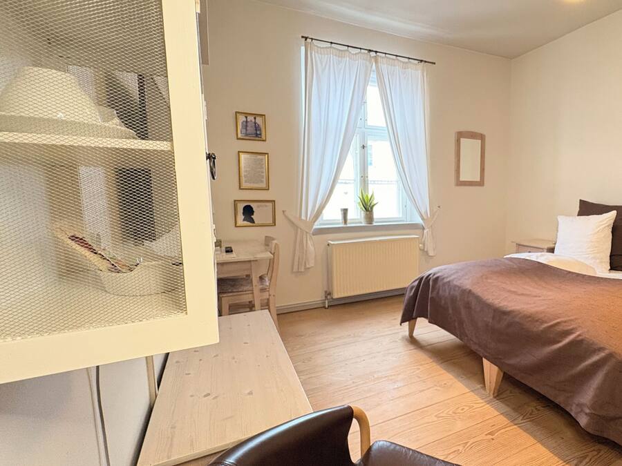 Un dormitorio con cama, escritorio y silla.