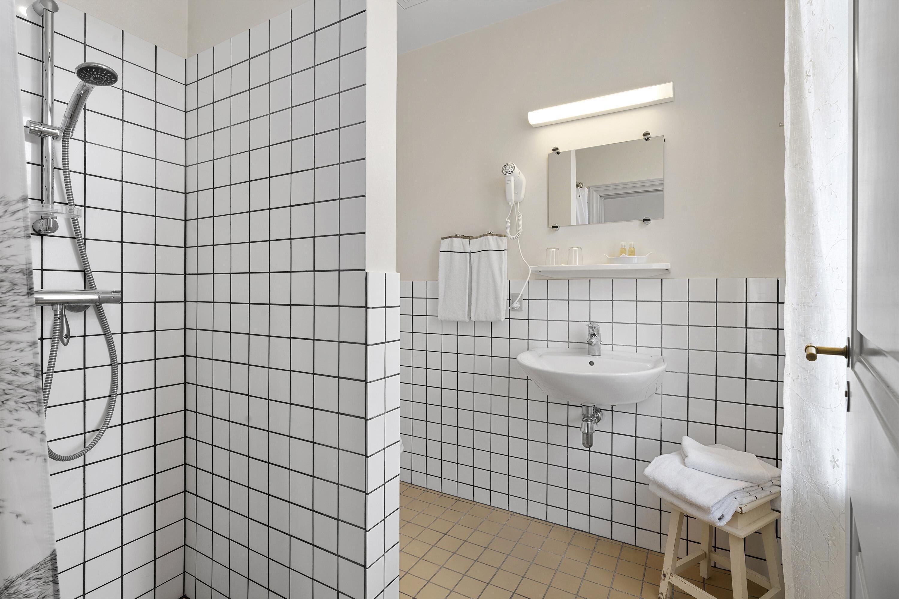Ein Badezimmer mit Dusche, Waschbecken und Spiegel.