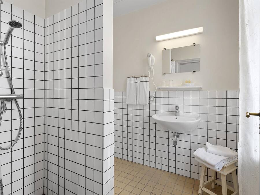 Ein Badezimmer mit Dusche, Waschbecken und Spiegel.
