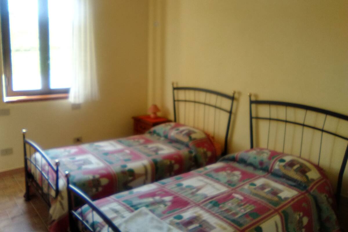 Une chambre avec deux lits, une fenêtre et une table de chevet.