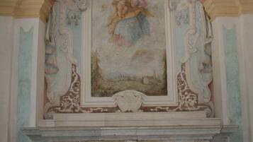 An ornate architectural detail with a fresco, a marble base, and a checkered floor.
