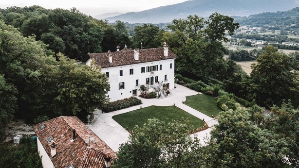 A large white building with a symmetrical facade, surrounded by lush greenery and a well-maintained lawn. - Villa San Liberale - Suites & Wellness - Villa Veneta (Feltre)