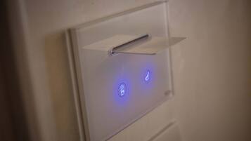 Un panel de control fijado a la pared, con botones iluminados y una ranura para tarjetas.