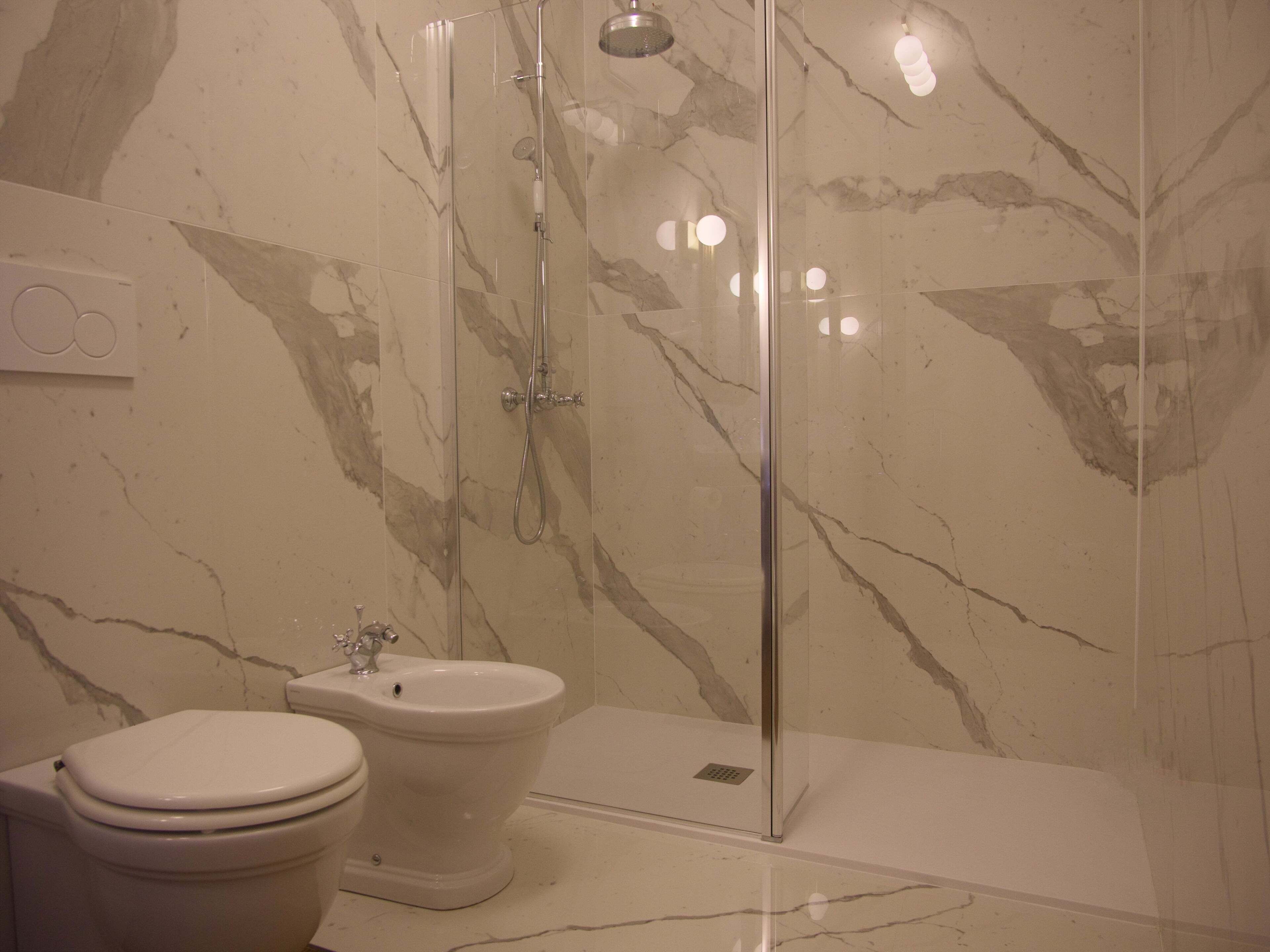 A bathroom with a glass-enclosed shower, a toilet, and a bidet.