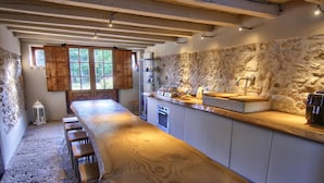 A long wooden bar with stools, stone walls, and a stone fireplace. - Villa San Liberale - Suites & Wellness - Villa Veneta (Feltre)