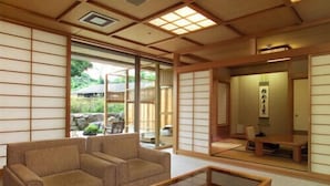 Une pièce de style japonais traditionnel, avec un sol recouvert de tatamis, une petite table basse en bois et un canapé.