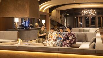 A modern lobby with a seating area, a staircase, and a bar.