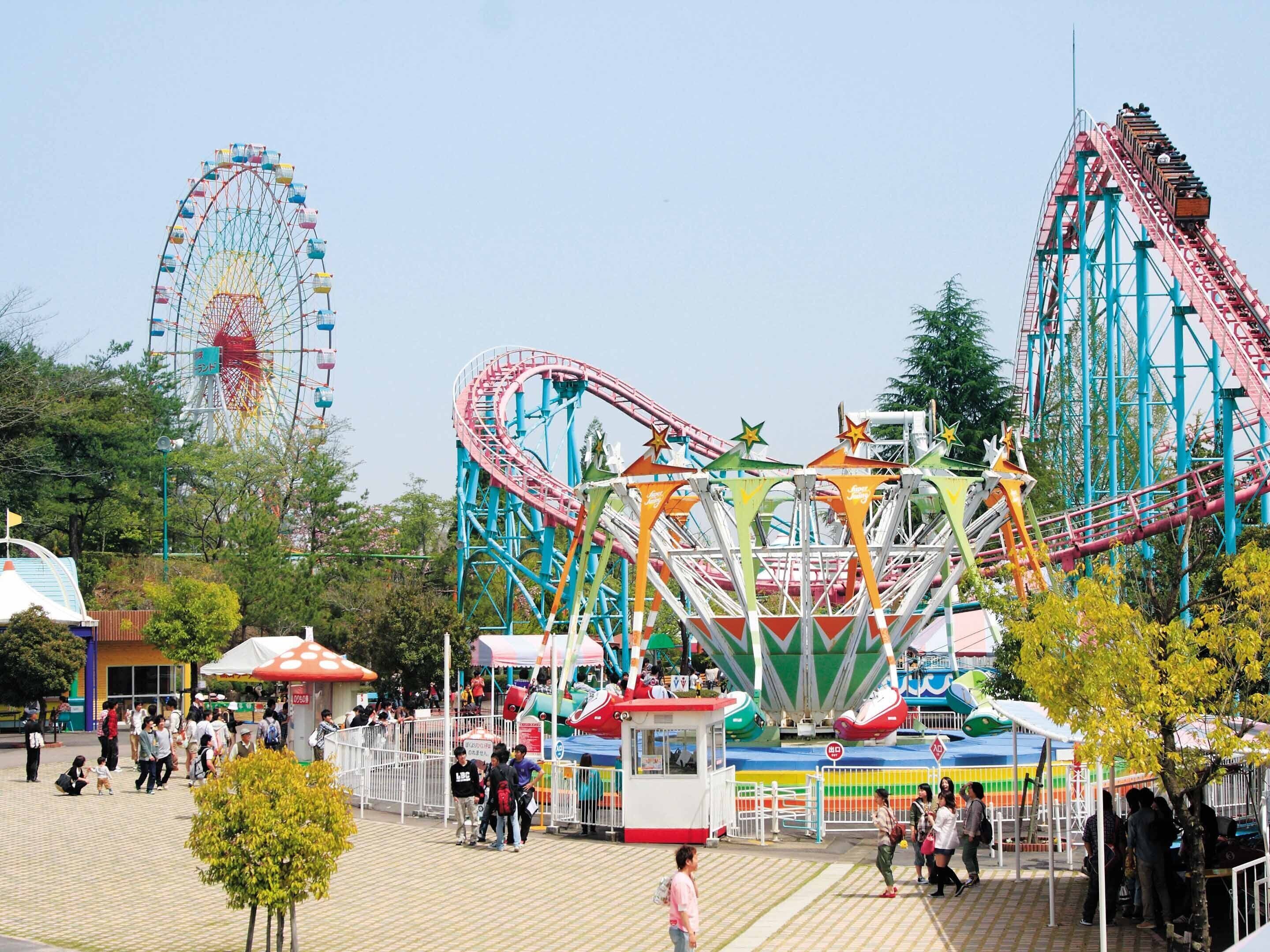 A roller coaster with a colorful track and a Ferris wheel in the background.