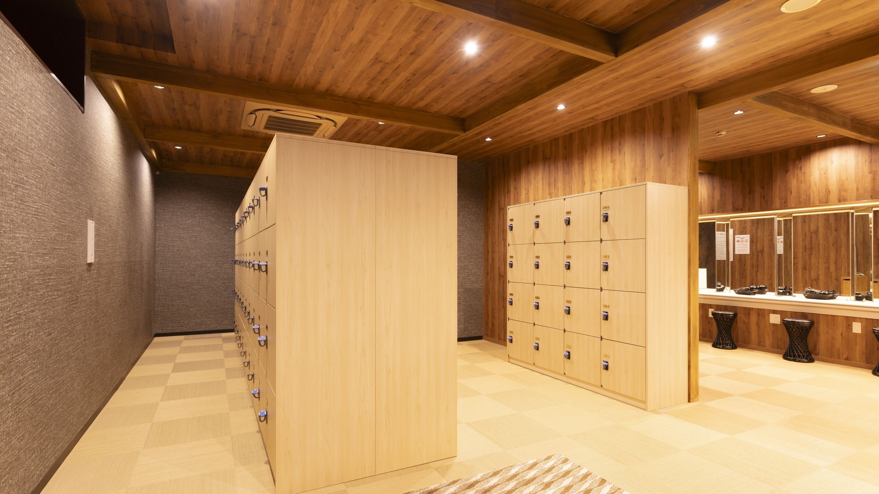 A wooden locker room with multiple lockers, a shoe shine station, and a checkered floor.