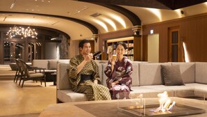A modern interior with a sofa, a glass table with a candle, and a chandelier. - Ooedo Onsen Monogatari Premium Enakyo (Ena)