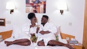 A hotel room with a bed, two bedside lamps, a painting on the wall, and a nightstand with a tissue box and a remote control. - Volta Hotel Akosombo (Akosombo)