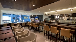 A modern café interior with bar seating, tables, and a view of the cityscape. - First Cabin Akasaka (Tokyo)