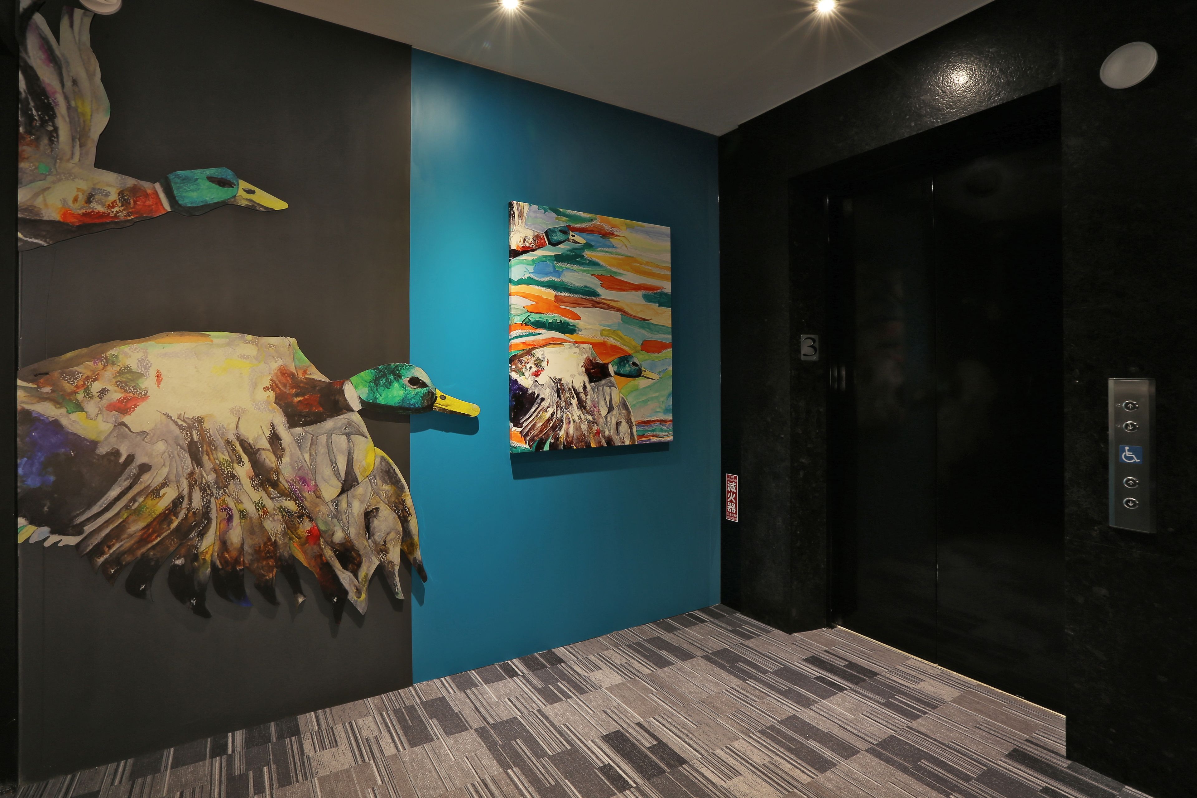 A modern elevator with a blue wall and a painting.