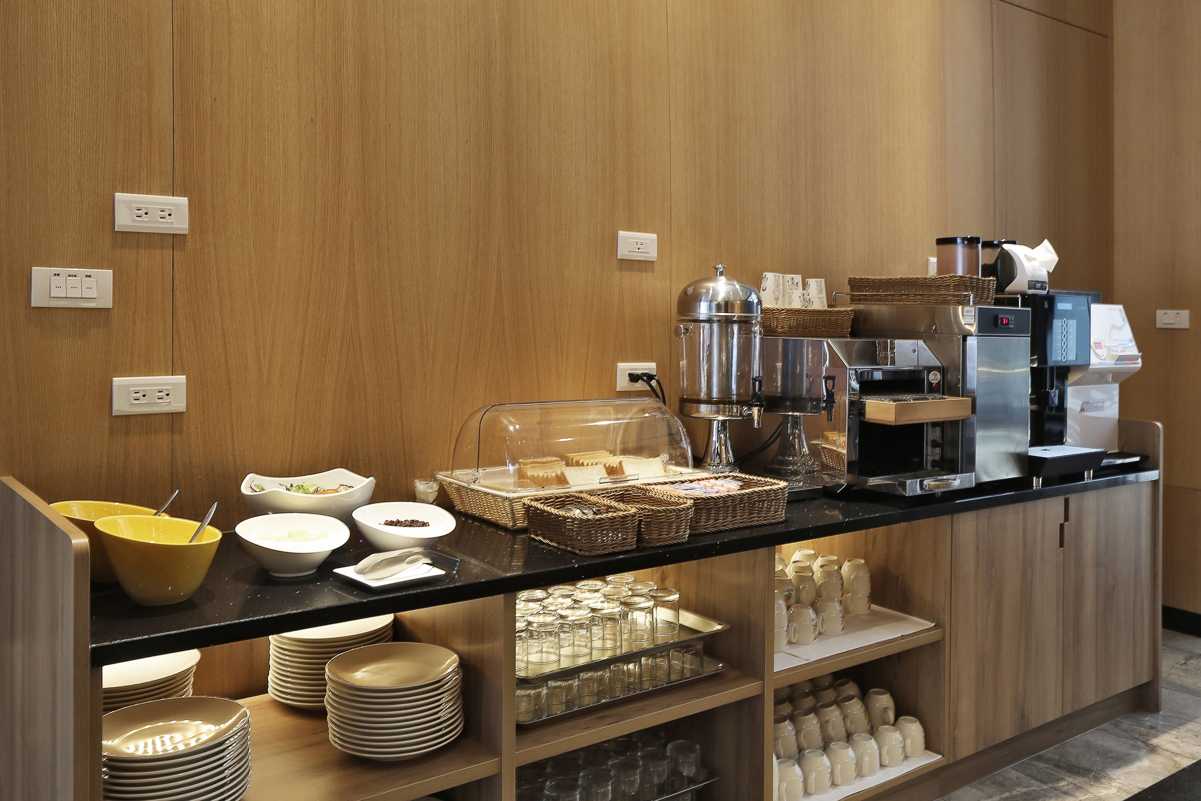 Un espace buffet proposant divers plats, une machine à café et un distributeur de boissons en libre-service.