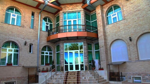 Un edificio de varios pisos con una escalera central, ventanas grandes y un balcón.