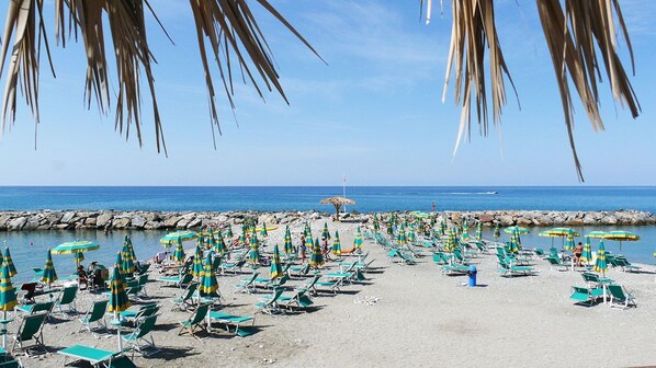 Privat strand, solsenger, parasoller og strandbar