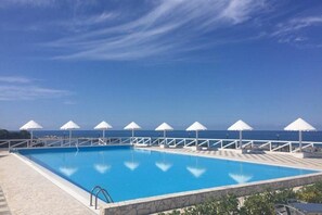 Outdoor pool, a rooftop pool, pool umbrellas, pool loungers