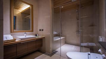 A modern bathroom with a large mirror, a wooden vanity, a glass-enclosed shower, and a white toilet.