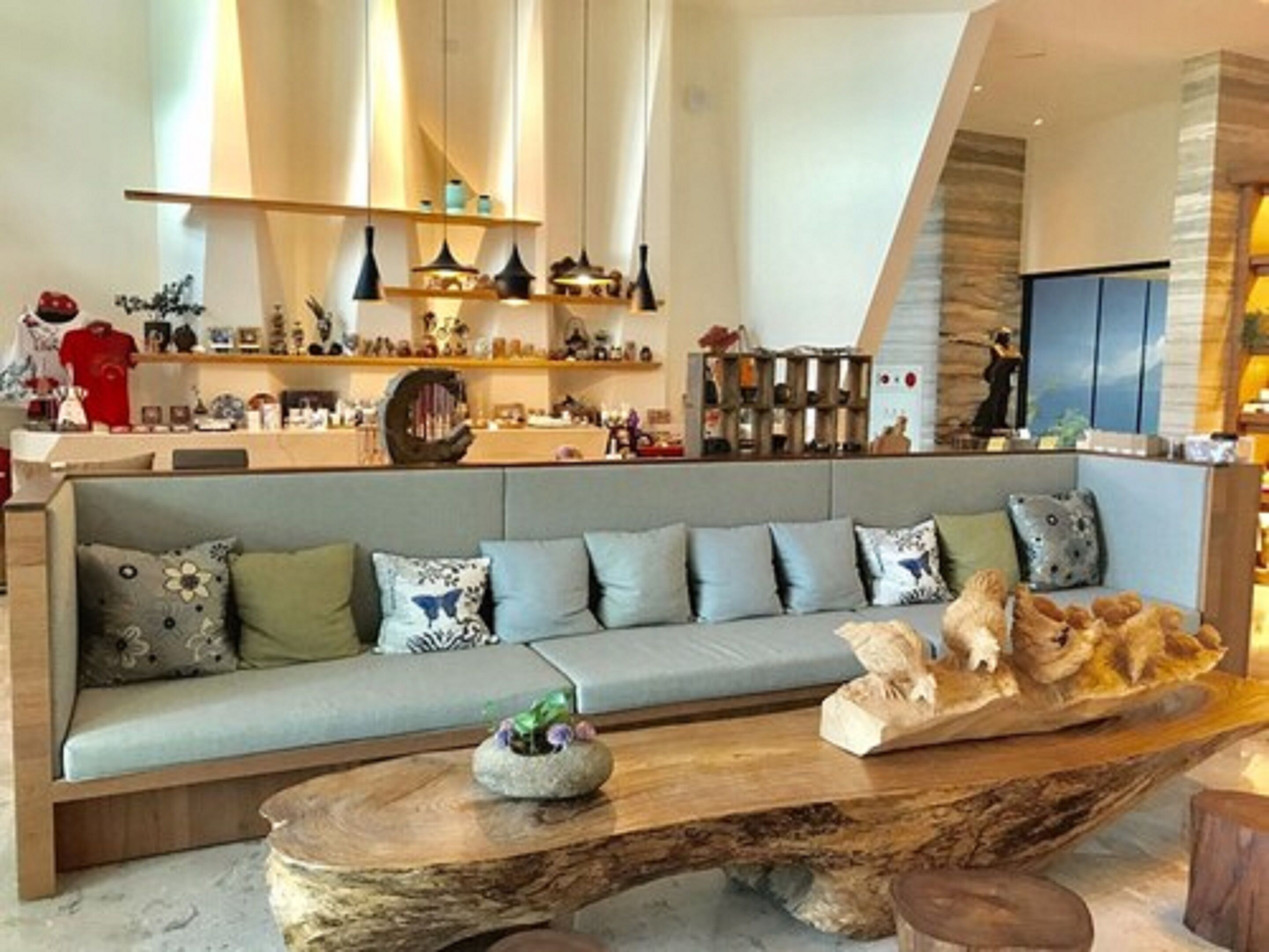 Un soggiorno moderno con un divano grigio, un tavolino in legno e oggetti decorativi.