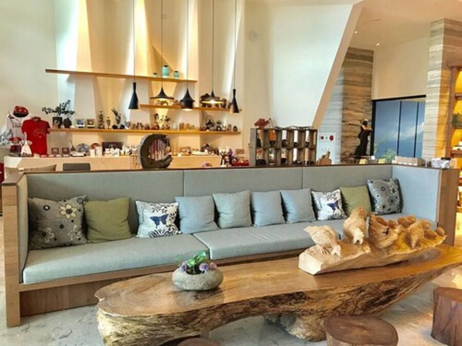 Un soggiorno moderno con un divano grigio, un tavolino in legno e oggetti decorativi.