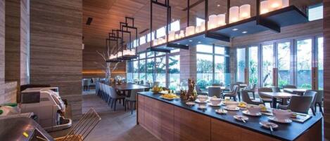 Una cocina moderna con una isla central, armarios de madera e iluminación colgante.