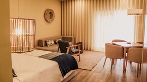 A hotel room with a bed, a sofa, a desk, and a chair. - Hotel Neptuno (Peniche)