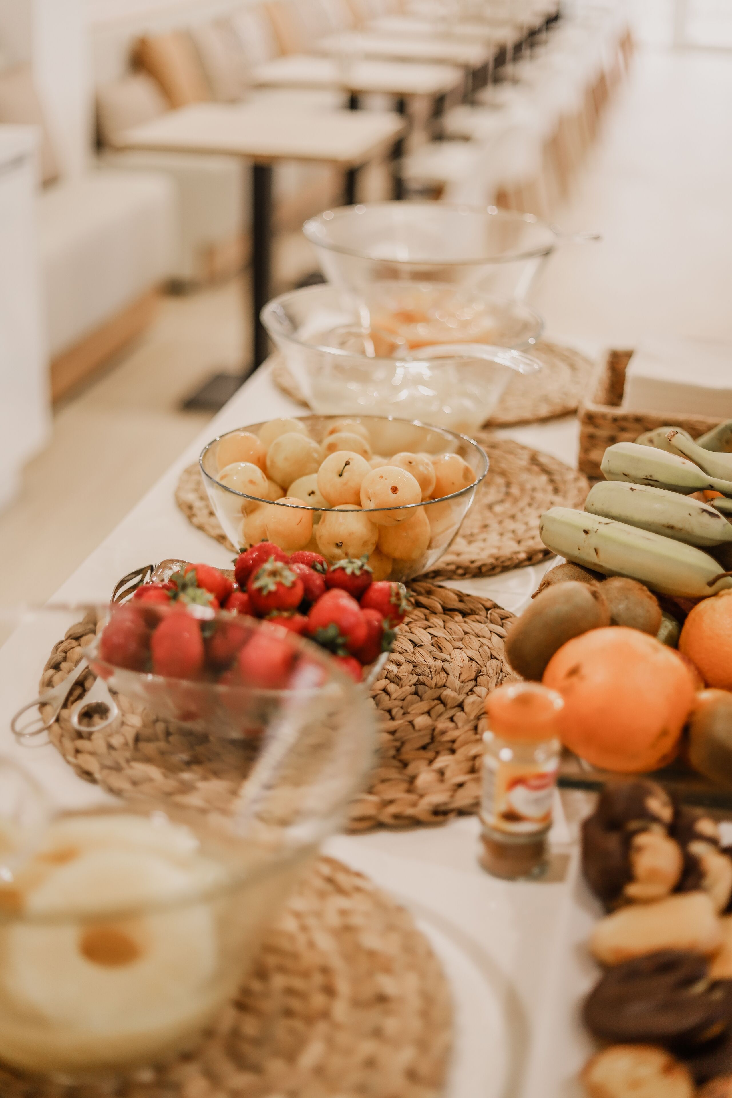 Una mesa de buffet con diversos alimentos, como frutas, pastelería y salsas.