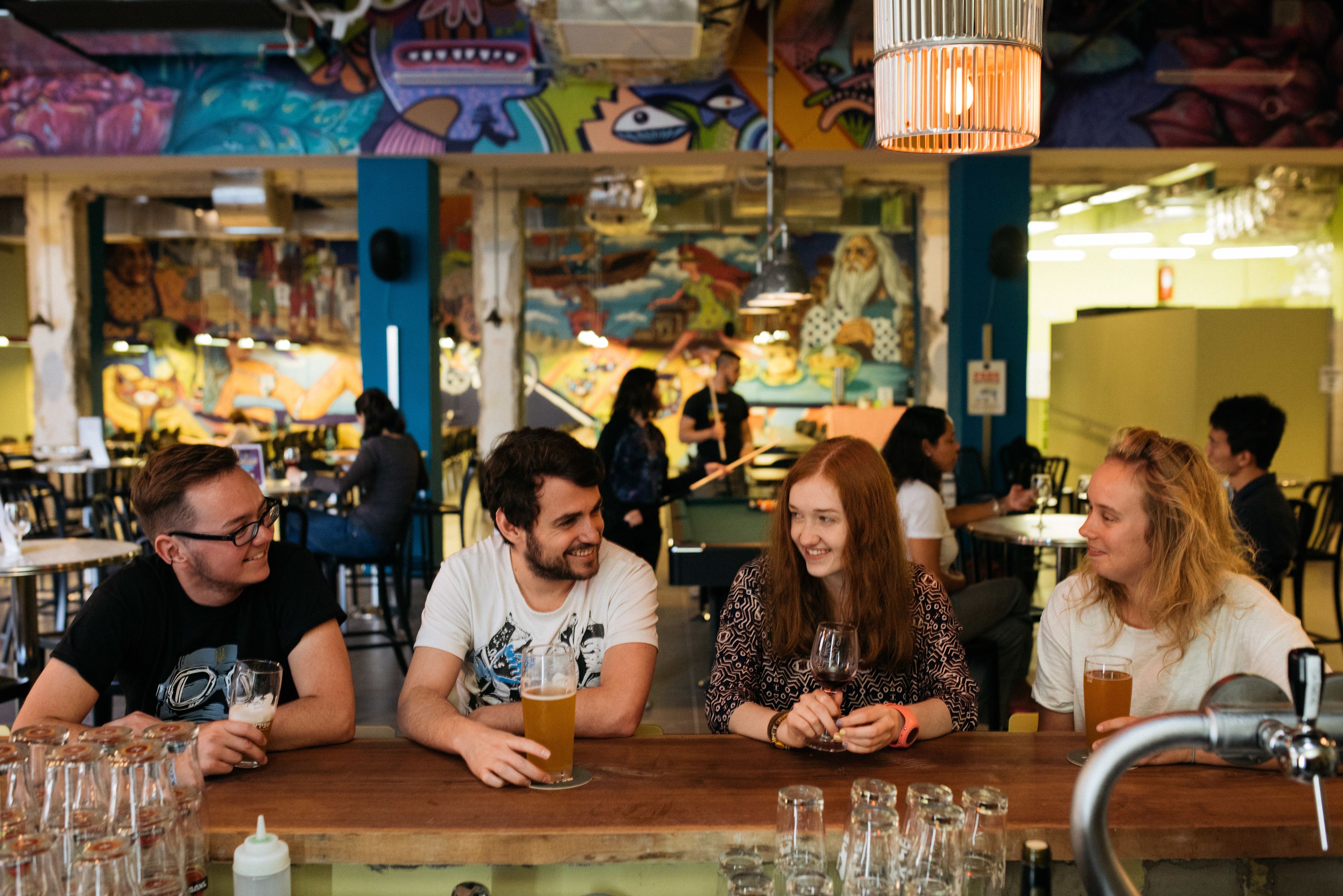 Una zona de bar con mostrador de madera, vasos y botellas.