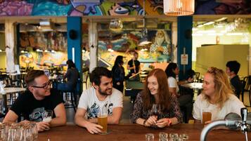 Una zona de bar con mostrador de madera, vasos y botellas.