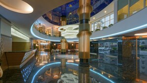 A spacious lobby with a high ceiling, a central column, and a starry ceiling design. - Asia Beach Resort & Spa Hotel (Alanya)