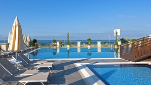A pool area with lounge chairs and umbrellas, a clear view of the ocean, and a sign for the Asiatique Hotel. - Asia Beach Resort & Spa Hotel (Alanya)