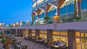 A multi-story hotel with outdoor seating areas and a modern architectural design. - Asia Beach Resort & Spa Hotel (Alanya)