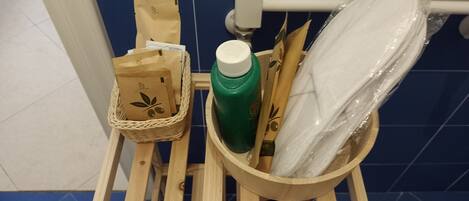 A wooden stool with a basket containing paper bags, a green bottle, and a wrapped item.