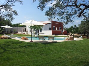 A modern house with a swimming pool, surrounded by a well-maintained lawn and trees. - B&B Villa Giorgia (Monopoli)