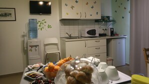 A compact kitchen with white cabinets, a microwave, and a water dispenser. - B&B Bagheria (Bagheria)