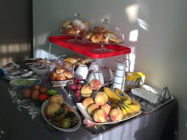 Un bufé de desayuno con diversos pasteles, frutas y bebidas.