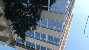 A multi-story building with large windows and a tree in front. - B&B Bagheria (Bagheria)