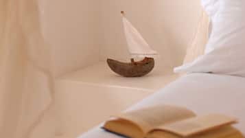 Relax in a serene bedroom with a nautical touch, featuring a cozy reading nook and a peaceful atmosphere.