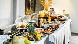 Uma mesa de buffet com diversos alimentos e acompanhamentos.