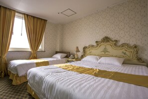 A hotel room with two beds, a nightstand, a lamp, and a window with curtains.