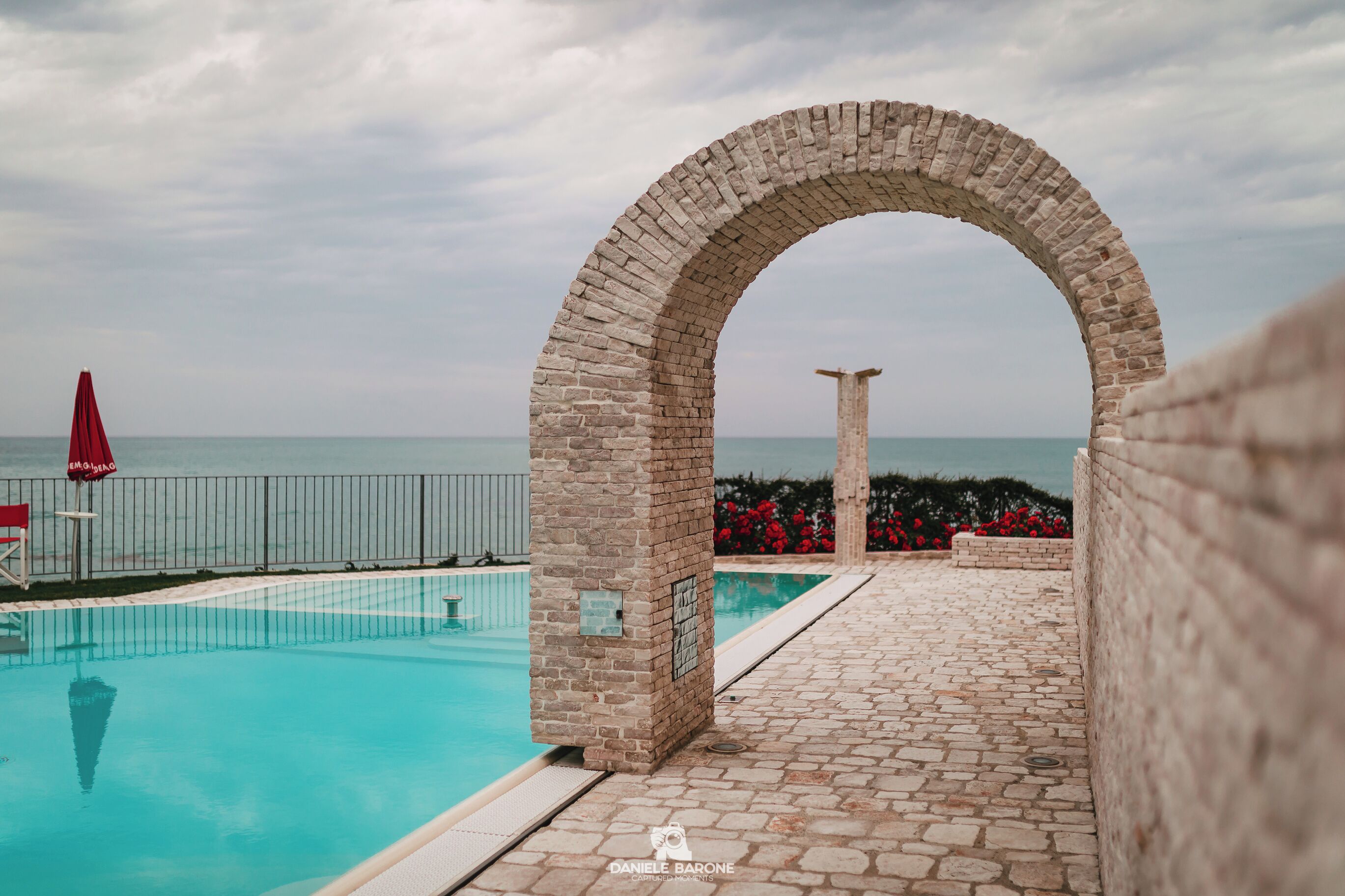 Piscina all'aperto, una piscina a sfioro, lettini