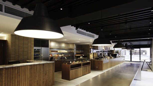 Angolo bar moderno con banconi in legno e illuminazione a sospensione.