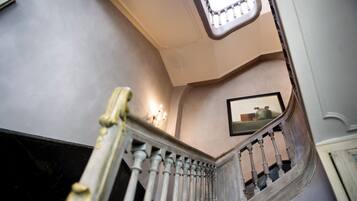 A staircase with a white balustrade and a light fixture above.