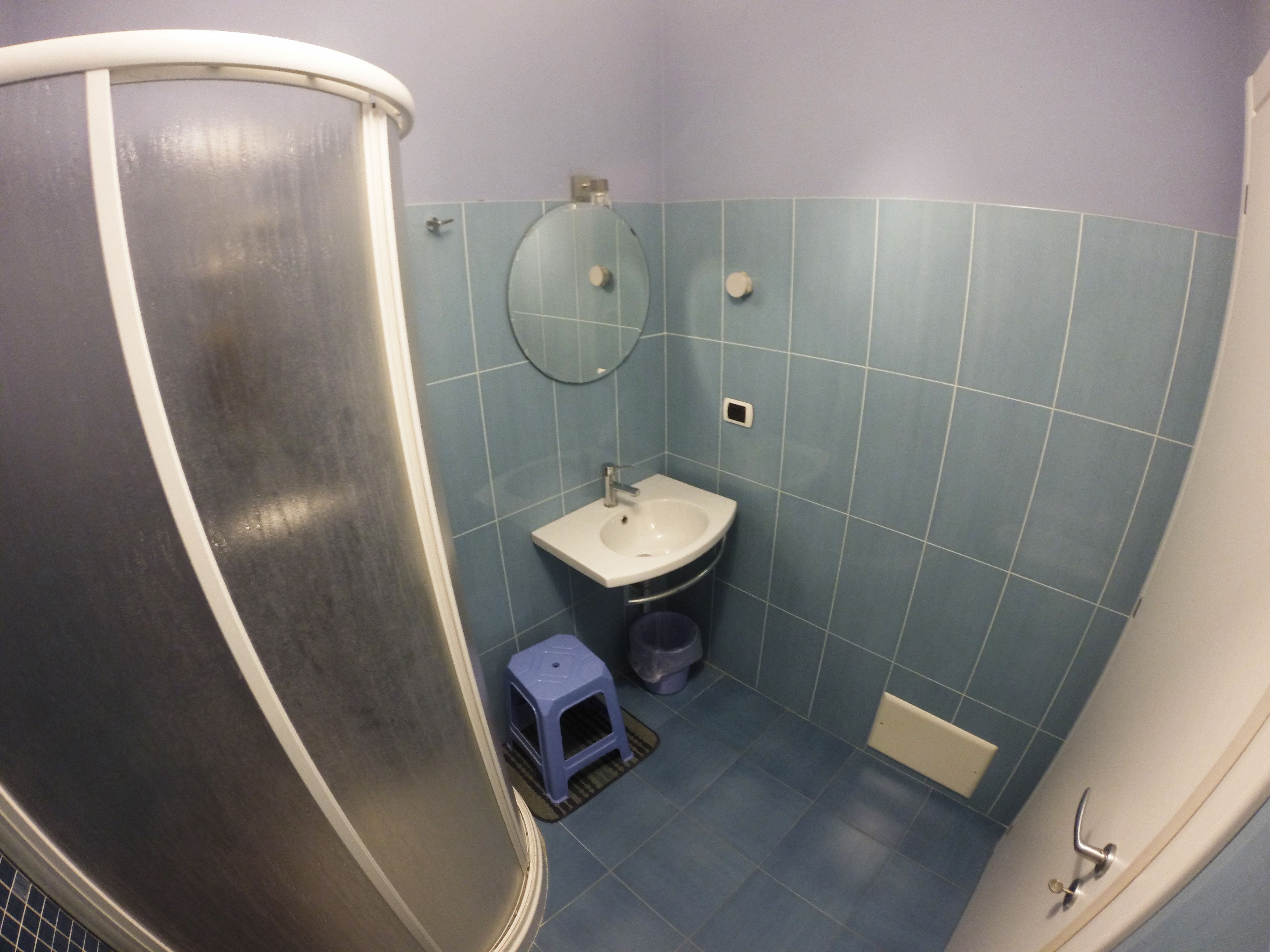 A bathroom with a shower, sink, and toilet.