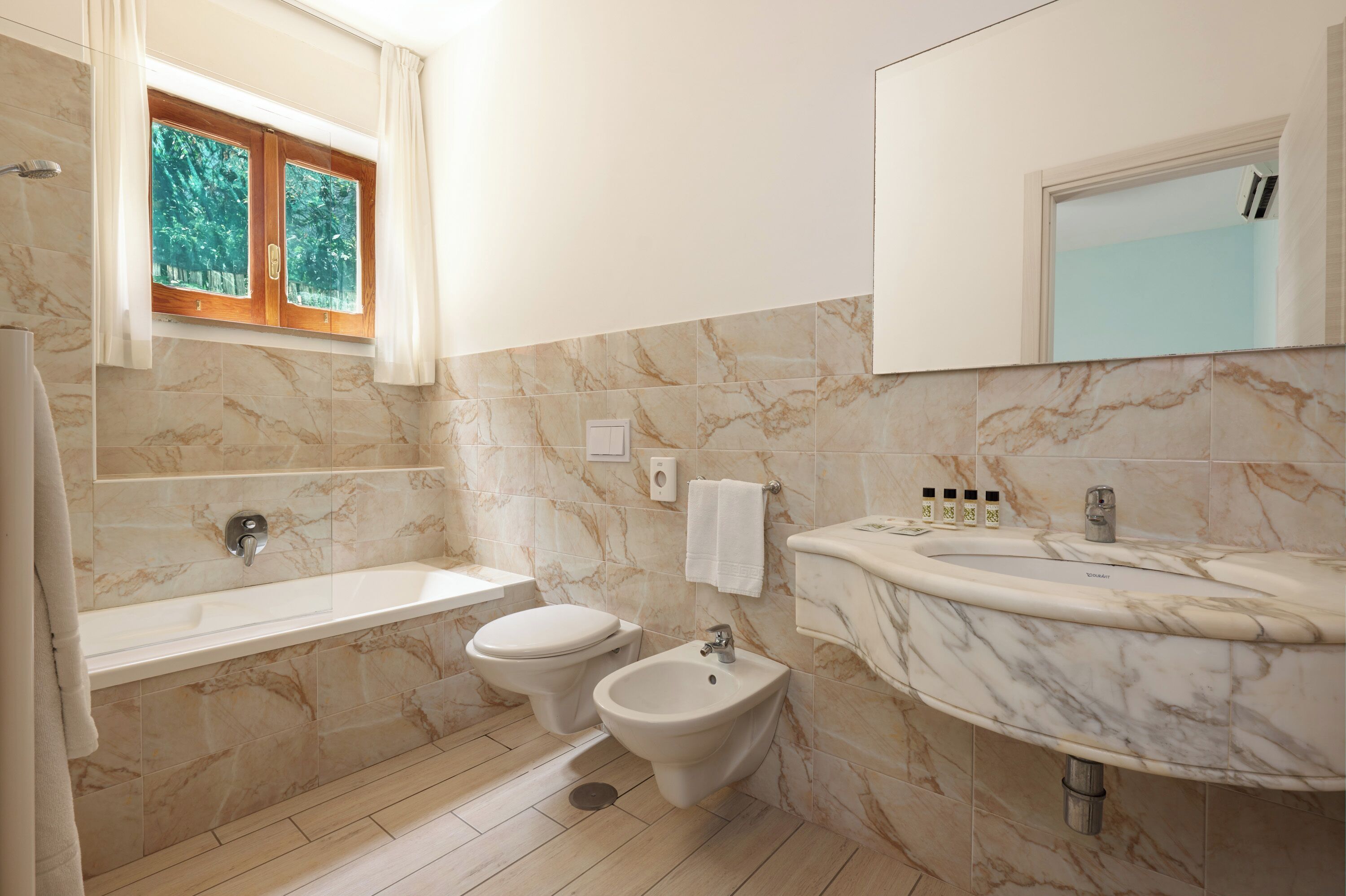 Un baño con bañera, bidé, inodoro y lavamanos.